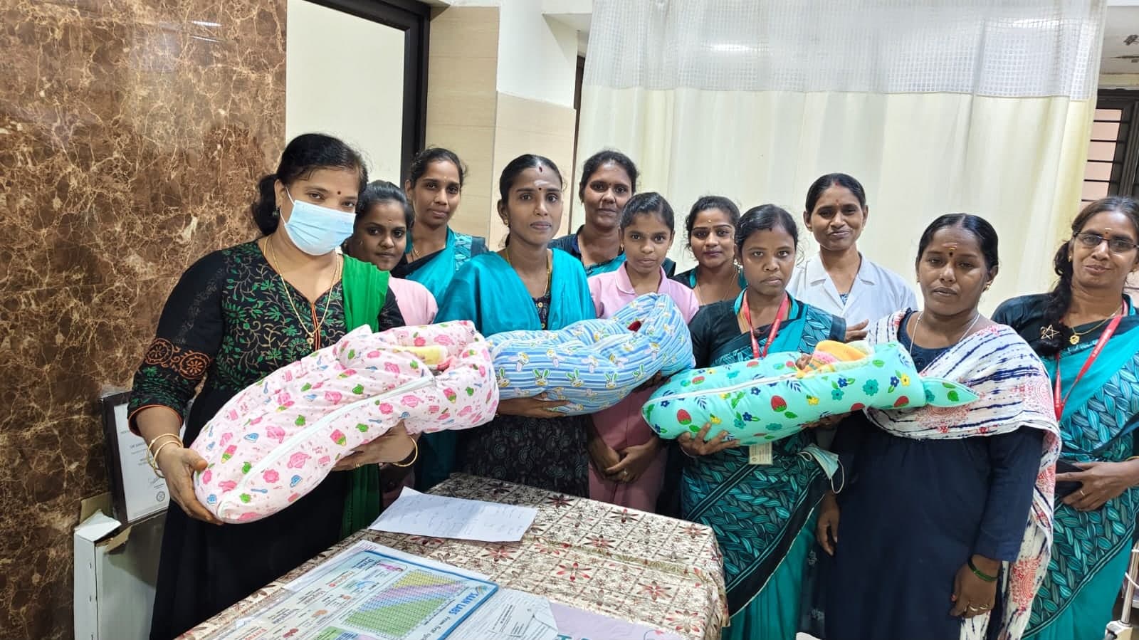 Care team and mothers gathered with newborns