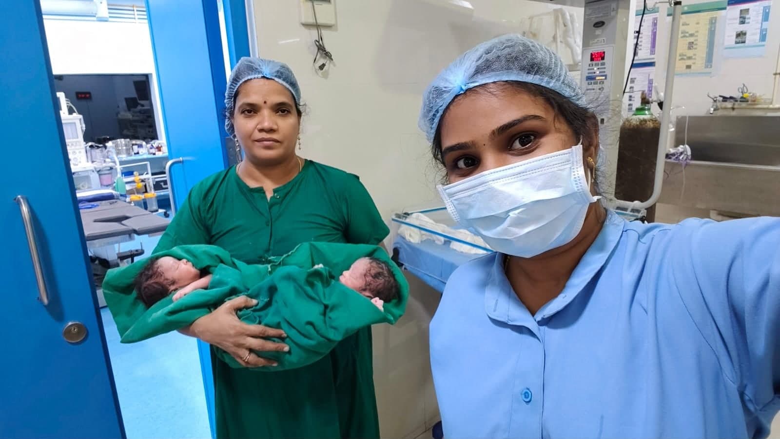 Member of the care team holding newborn twins